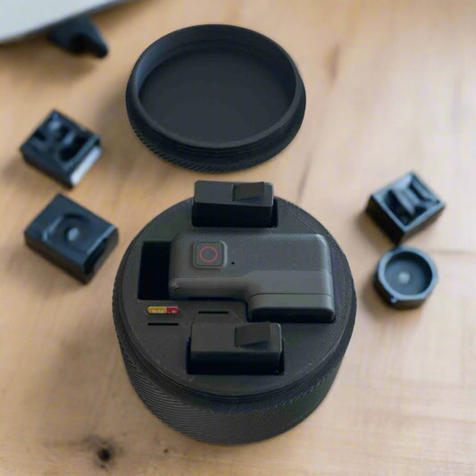 Μαύρη 3D printed θήκη GoPro με κάμερα και μπαταρίες σε ξύλινο φόντο.